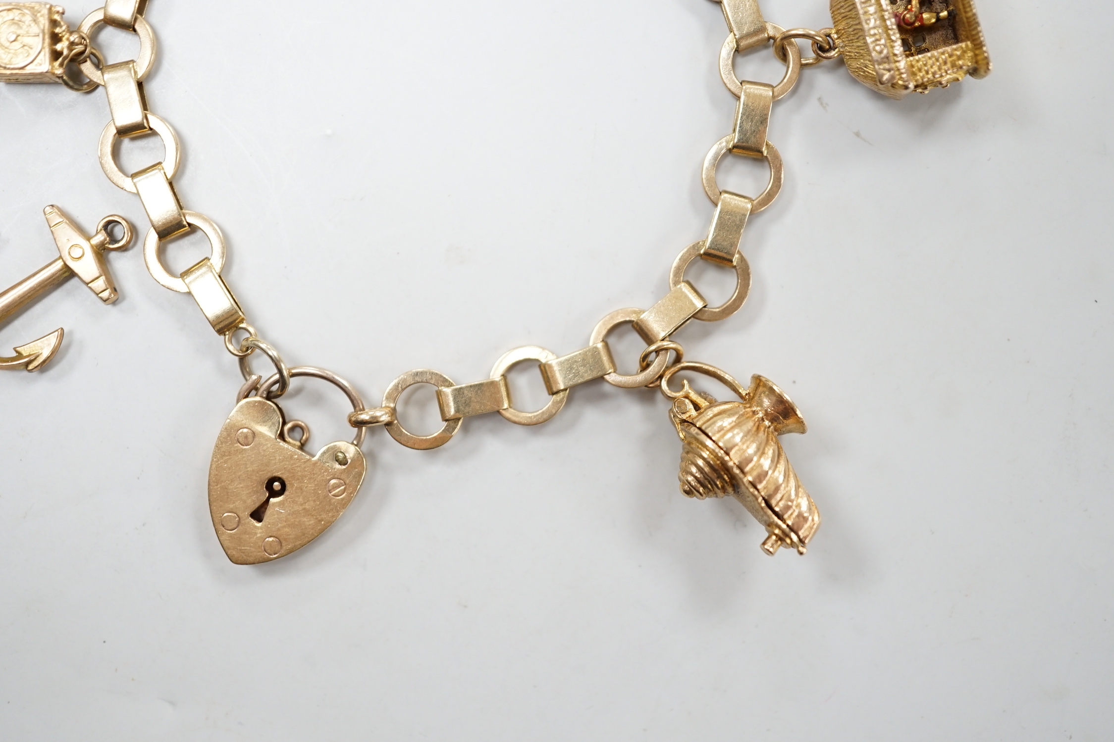 A 1950's 9ct gold charm bracelet hung with six assorted charms, gross weight 25.5 grams.